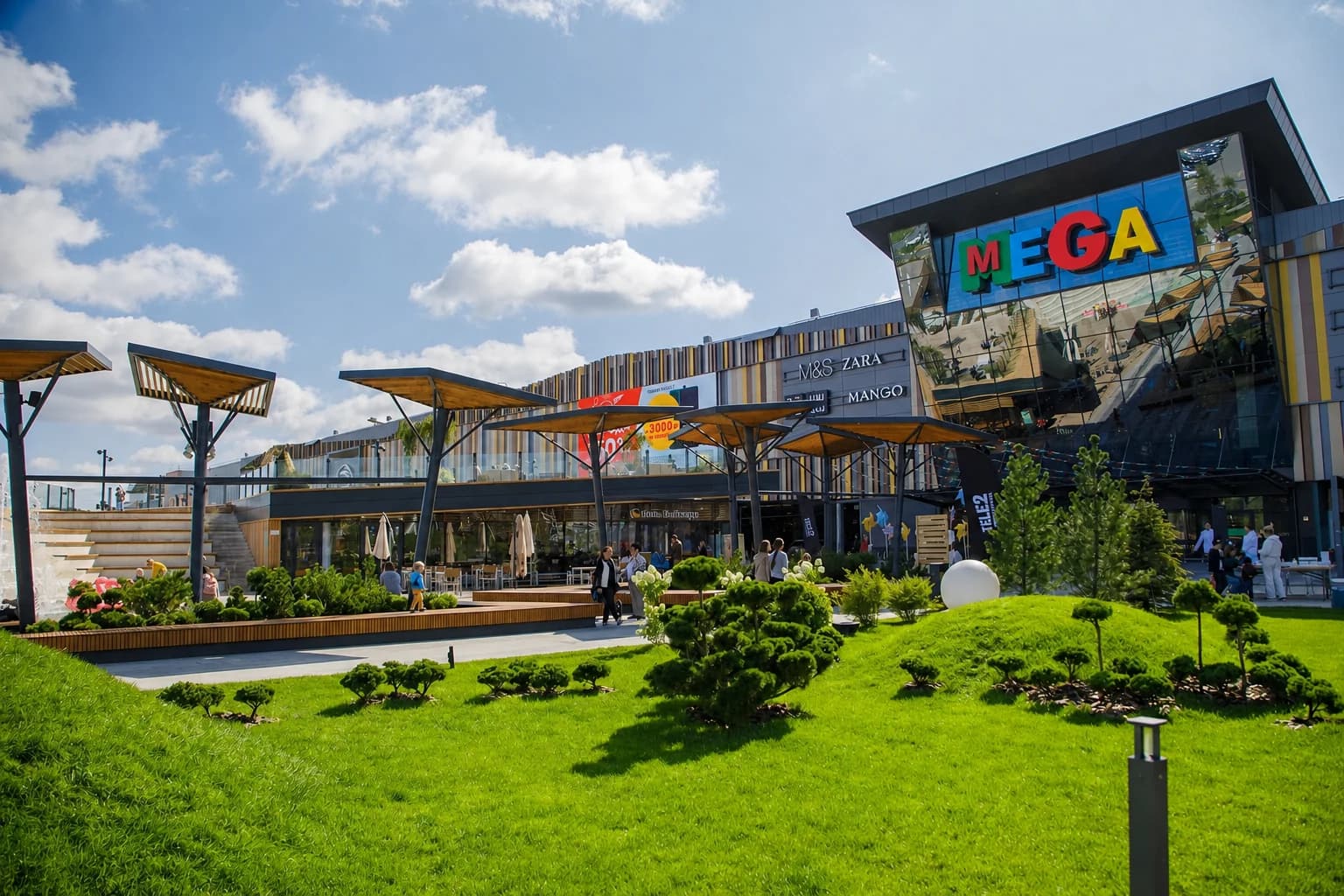 The environment in front of a shopping centre entrance in high summer: shade structures, planting and water at the point where people stop